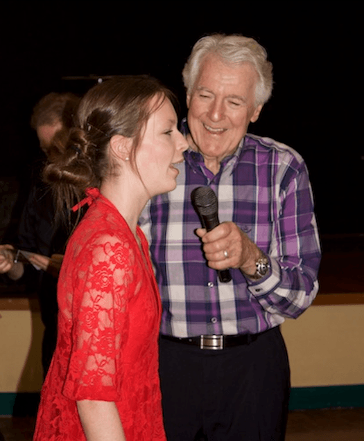 Peter Ross giving a girl a microphone